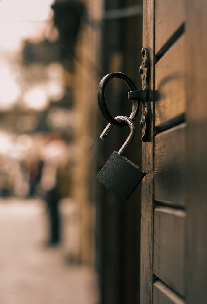 Crafting Captivating Headlines: Your awesome post title goes here An unlocked padlock hanging on a wooden door in an urban setting, symbolizing security or freedom.